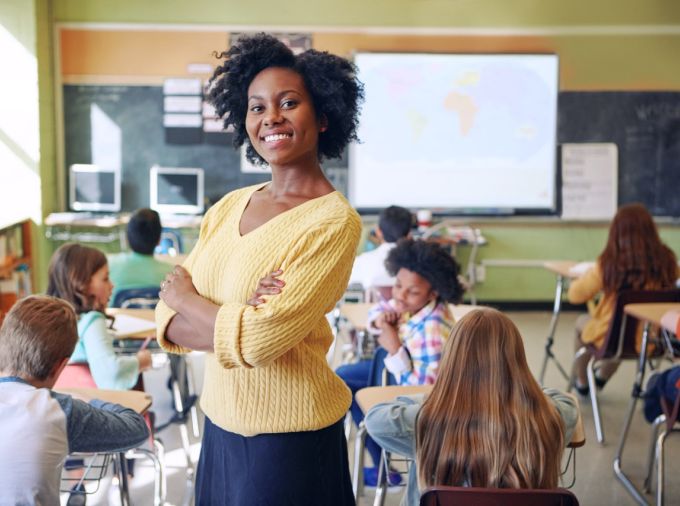 Teacher smiling with students in classroom.