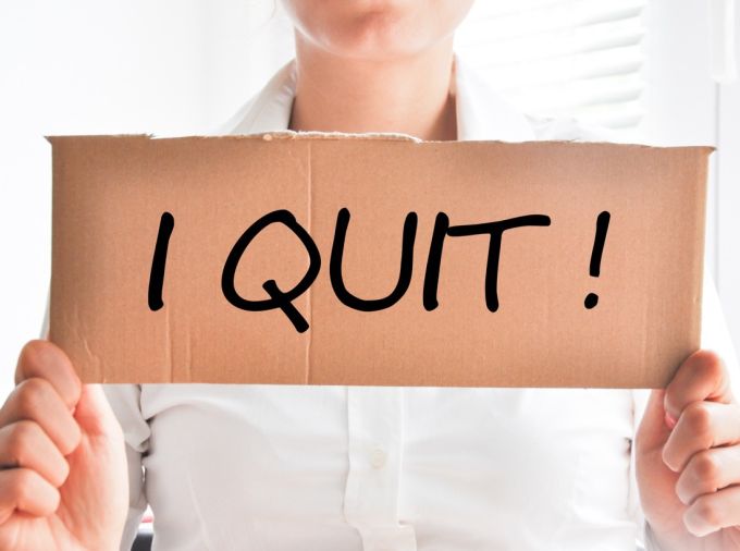 Concept of teacher leaving the profession. Person holding sign with the words "I QUIT."